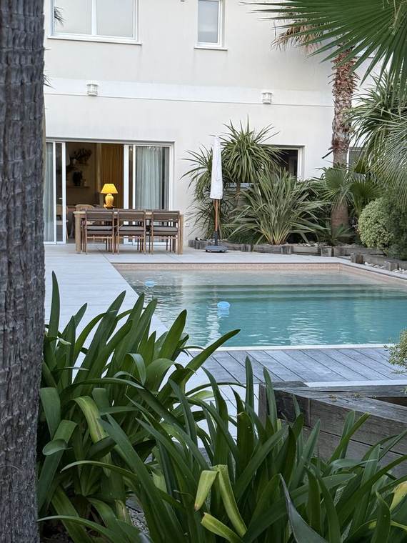 Terrasse claire et agapanthes en fleurs au premier plan